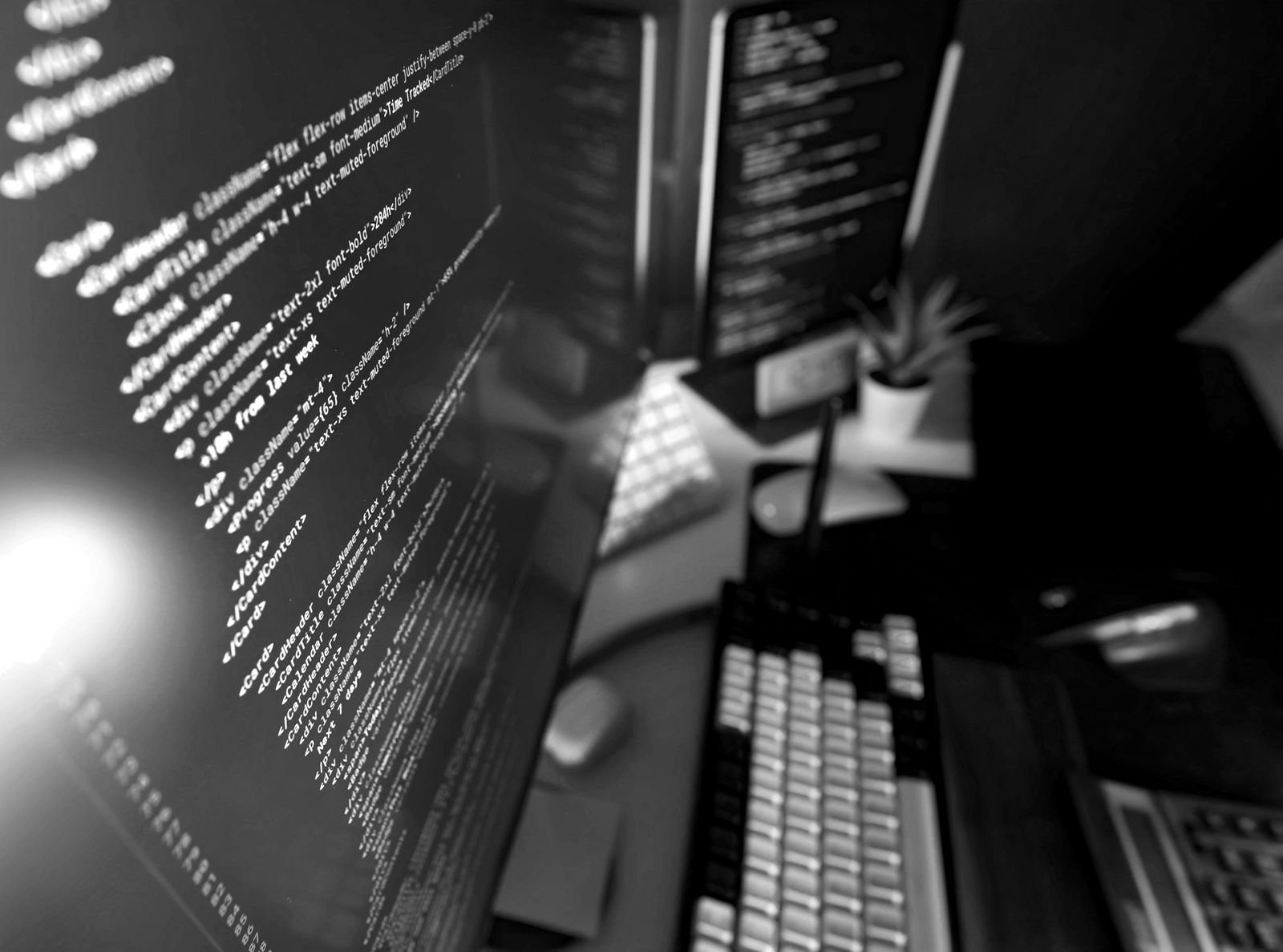 Lines of code on two monitors at a desk