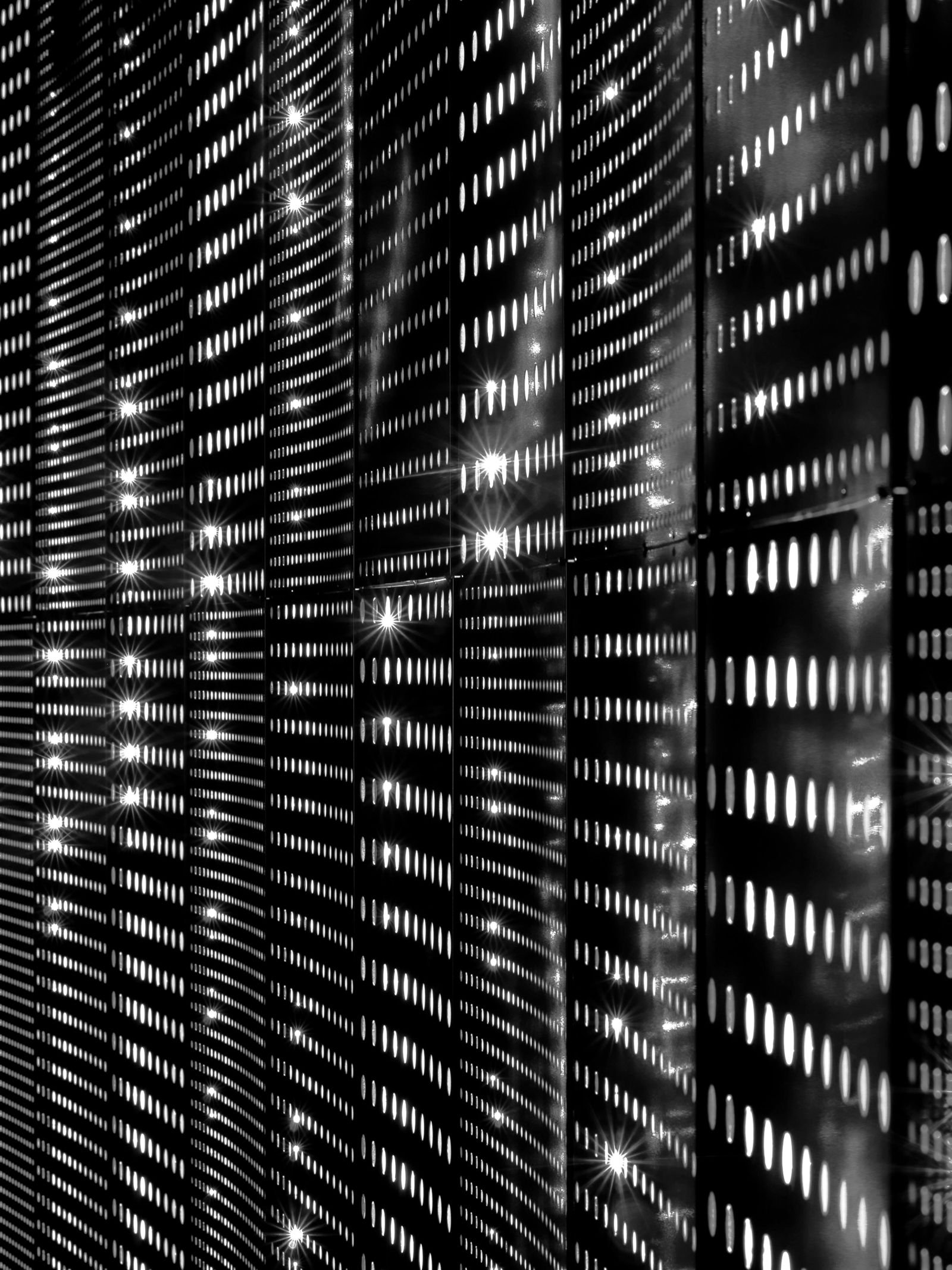 Server racks with rows of small lights in a dark room