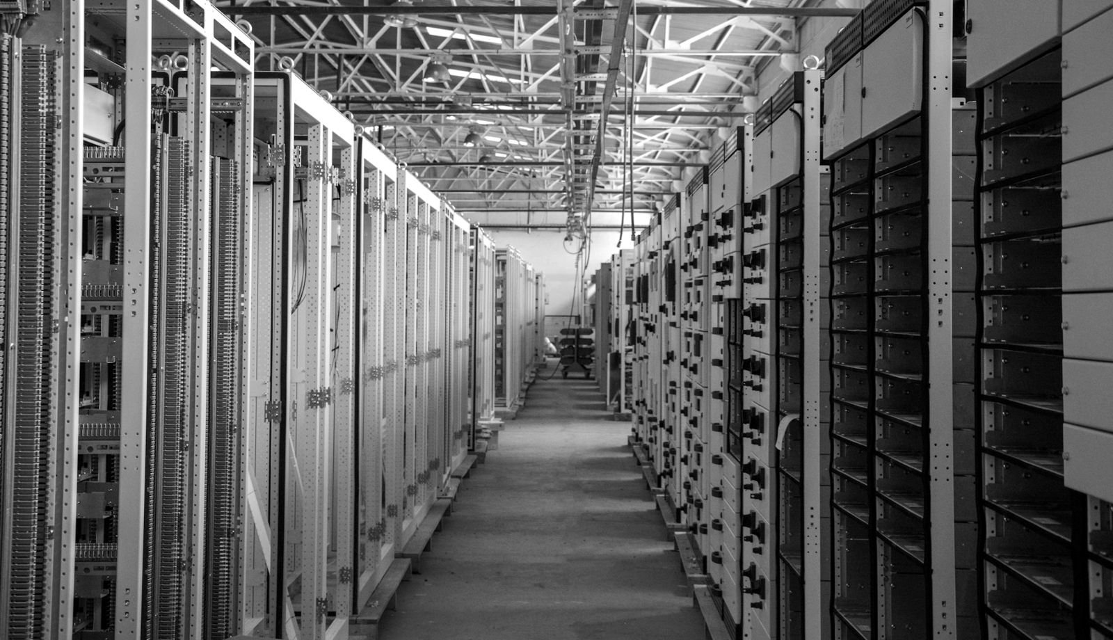 An aisle between rows of metal equipment racks